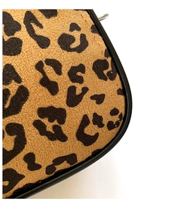 Detailed close-up of leopard print fabric with high-quality black leather edging finish