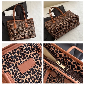 Detailed macro view of the leopard print tote bag with brown leather trim and gold zipper