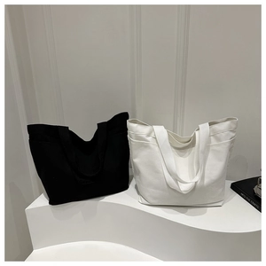 Detail showing high-capacity canvas tote bags in black and white with side pockets