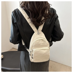 Detail view of cream mini backpack with wrinkled texture fabric and metallic zipper pulls