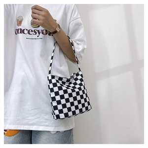 Détail d'un sac à bandoulière en toile à damier noir et blanc avec sangle assortie