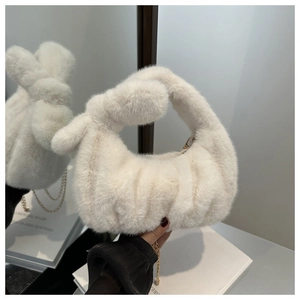 Détail du sac à main en peluche blanche avec texture rayée verticale et chaîne dorée chic