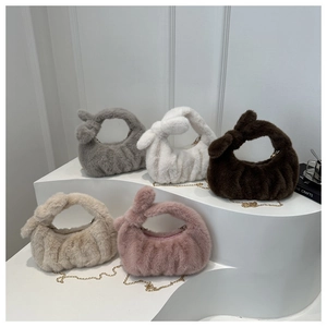 Détail de sacs à main en peluche avec poignées nouées et chaînes dorées sur socle blanc
