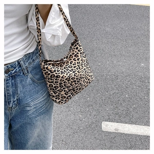 Détail du sac hobo à imprimé léopard porté à l'épaule avec une tenue décontractée