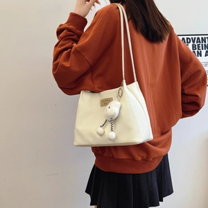 Minimalist beige tote bag with shoulder straps and a cute cloud plush charm accessory