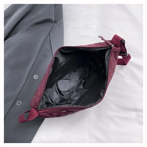 Detailansicht des geräumigen schwarzen Polyester-Innenfutters der weinroten Stepptasche