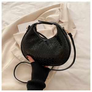 Détail du sac hobo croissant noir avec texture gaufrée tissée et ferrures dorées