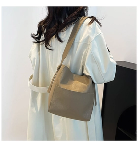 Detail of khaki bucket bag showing premium lychee texture on shoulder strap and side