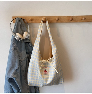 Detail of yellow and blue plaid canvas tote with a tomato graphic and handmade label