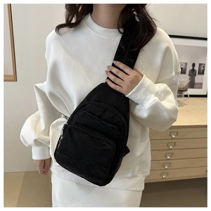 Detail of black nylon crossbody bag with dual zipper pockets and wide adjustable strap