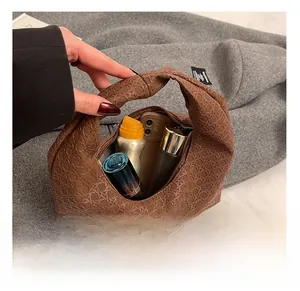 Detail view of woven brown hobo bag with knotted handle showing spacious interior capacity