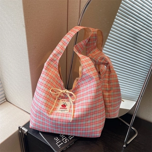 Detail of pink and blue checkered canvas tote bag with a handmade label and drawstring ties