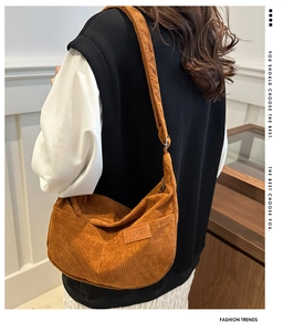 Close-up of brown corduroy crossbody bag featuring a stitched FASHION leather label