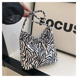 Détail montrant le sac fourre-tout en toile à motif zébré porté pour visualiser la taille