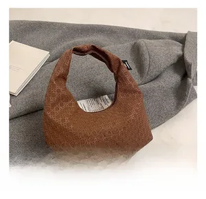 Detailed view of brown woven texture hobo bag placed on a grey wool coat for commute style