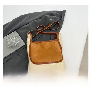 Detail of suede and faux shearling tote bag showing texture contrast and leather strap