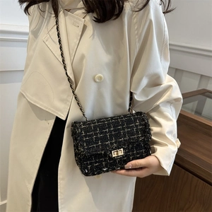 Detail of tweed crossbody bag with golden chain strap on model in trench coat