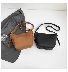 Detailed view of minimalist black and brown pebble leather tote bags with front pockets