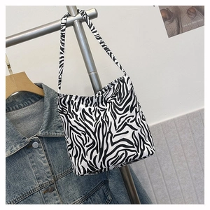 Détail d'un sac cabas chic avec motif zèbre suspendu sur un support en métal simple