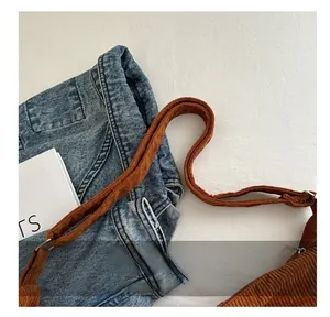 Close-up of brown corduroy tote bag strap with silver metal buckle and soft ribbed texture