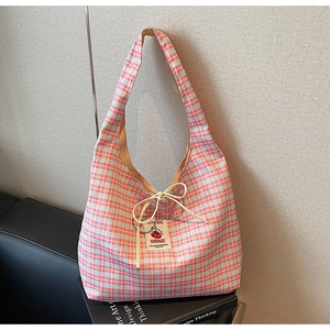 Detail of pink and blue checkered canvas tote bag with drawstring and handmade tomato label