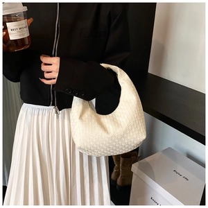 Detail of the minimalist off-white hobo bag with geometric embossed texture and crescent shape