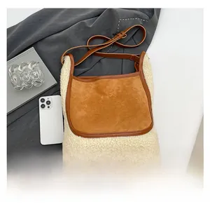 Detail view of plush beige faux fur tote with brown suede trim and adjustable strap