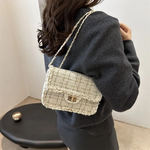 Elegant woven tweed chain bag for women worn by a model in a minimalist interior setting