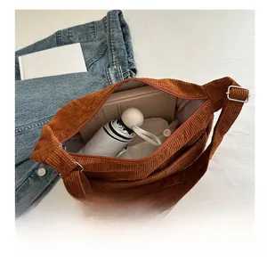Detailed interior of a brown corduroy tote bag showing large capacity for books and umbrella
