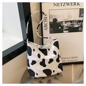 Gros plan détaillé du sac cabas en toile imprimé vache montrant le motif de taches noires