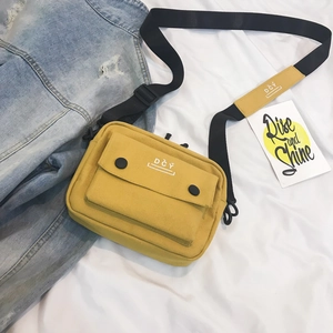 Detailed macro view of yellow canvas crossbody bag with DCY logo and adjustable black strap