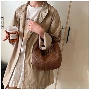 Detailed shot of brown textured hobo crescent bag styled with a khaki trench coat