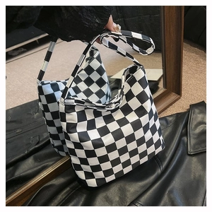 Détail du sac cabas en toile à damier avec motif de grille noir et blanc et poignées