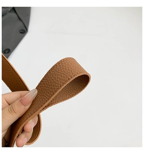Detailed macro view of the brown pebble grain leather texture and precise stitching detail