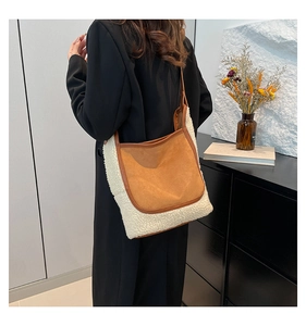 Detail of brown suede and white faux shearling shoulder bag on model with leather straps