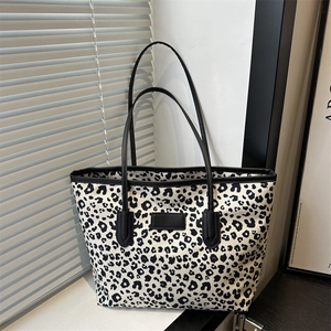 Fashionable leopard print canvas tote bag with black leather handles and modern chic design