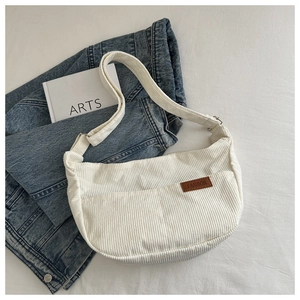 Detail of white corduroy shoulder bag with FASHION leather patch and adjustable strap