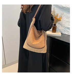 Detail of a large brown suede tote bag with cream faux fur trim and leather straps