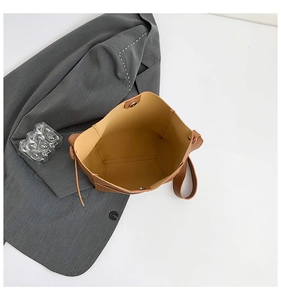 Detail of caramel leather tote bag interior showing pebbled texture and magnetic closure