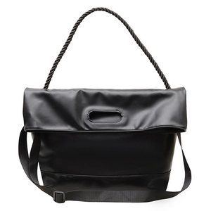 Minimalist black faux leather tote with thick twisted top handle and adjustable strap