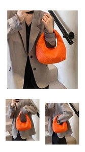 Detailed macro view of orange hobo bag with textured pattern shown in lifestyle setting