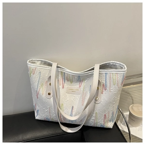 Gros plan détaillé des coutures ondulées colorées et de l'étiquette en cuir du sac cabas