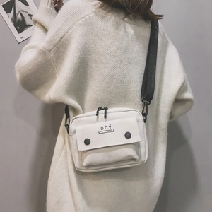 Detail of off-white canvas crossbody bag with black adjustable strap and DCY logo