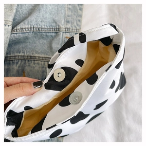 Détail du sac en toile à motif vache, fermoir magnétique et doublure jaune