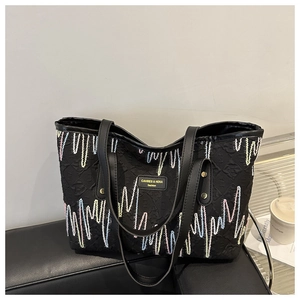 Détail du grand sac cabas noir avec broderie vagues arc-en-ciel et anses en cuir noir