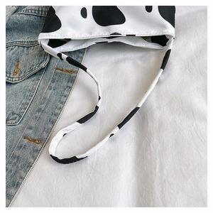 Gros plan de l'ouverture du sac cabas en toile à motif vache avec bandoulières