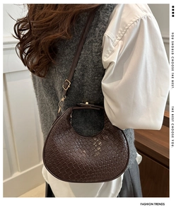 Detailed view of woven leather texture on a vintage brown crescent hobo shoulder bag