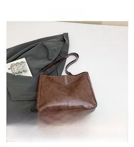 Detail view of large dark brown tote bag with premium vintage oil wax leather texture