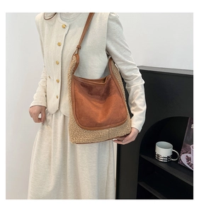 Detail of the textured brown suede and beige faux shearling patchwork shoulder bag for women
