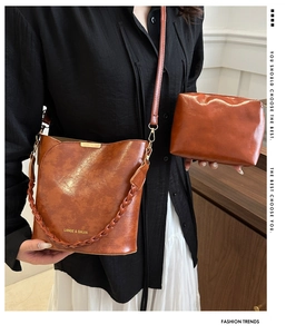 Vue détaillée du lot sac seau marron et pochette avec anse tressée et détails dorés